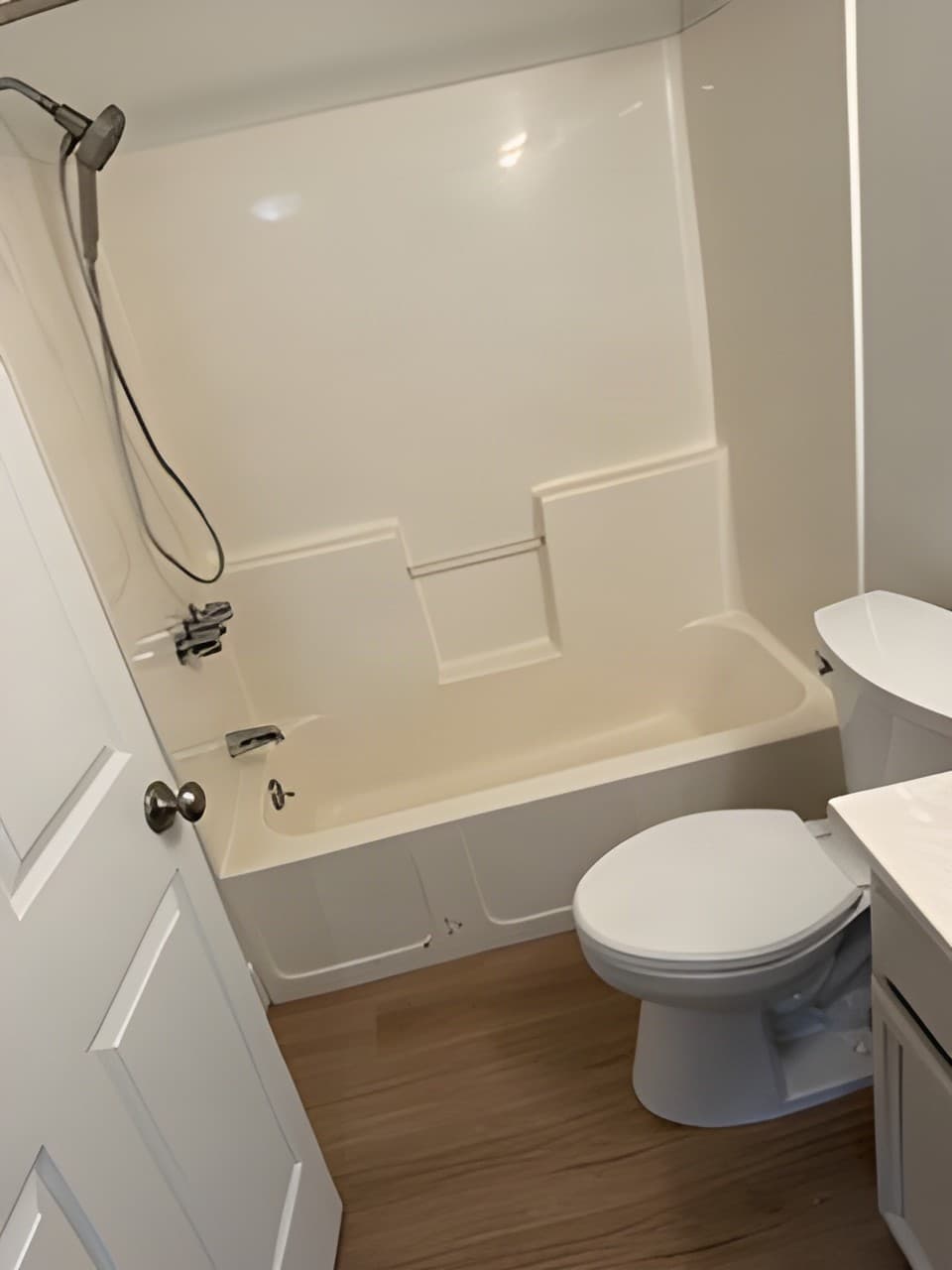 Clean bathroom with tub, shower, and toilet after a plumbing repair